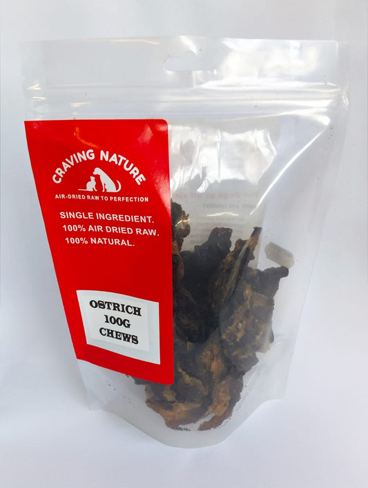A clear plastic stand-up pouch containing air-dried raw chews, with a bright red front label reading 'Craving Nature' and 'Ostrich 100g Chews'.